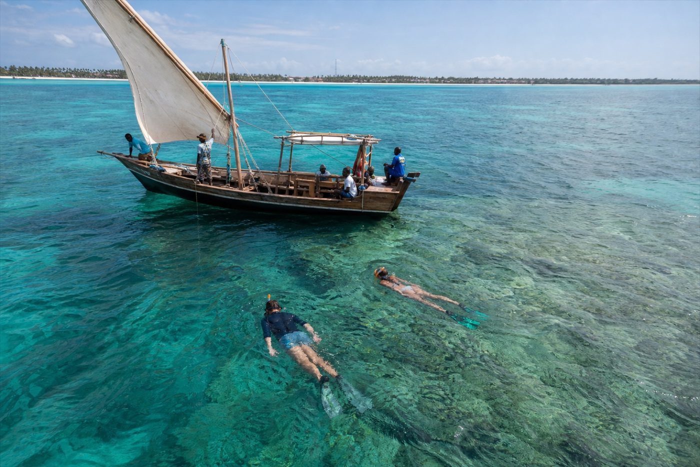 Traditional dhow and snorkellers in the clear waters near Diani Beach